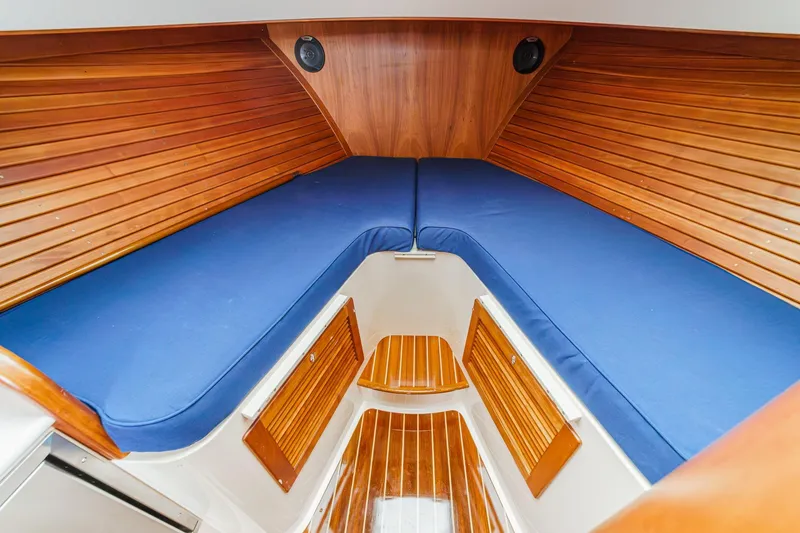 Slide: The Image of 2014 Hinckley Talaria 34 interior with blue cushions and wooden paneling. - 30