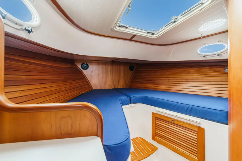 Slide: The Image of 2014 Hinckley Talaria 34 cabin interior with wooden paneling and blue cushions. - 31