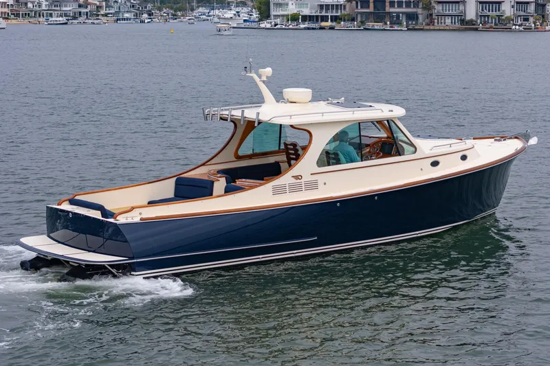 Slide: The Image of 2014 Hinckley Talaria 34 cruising on a calm waterfront with scenic background. - 4