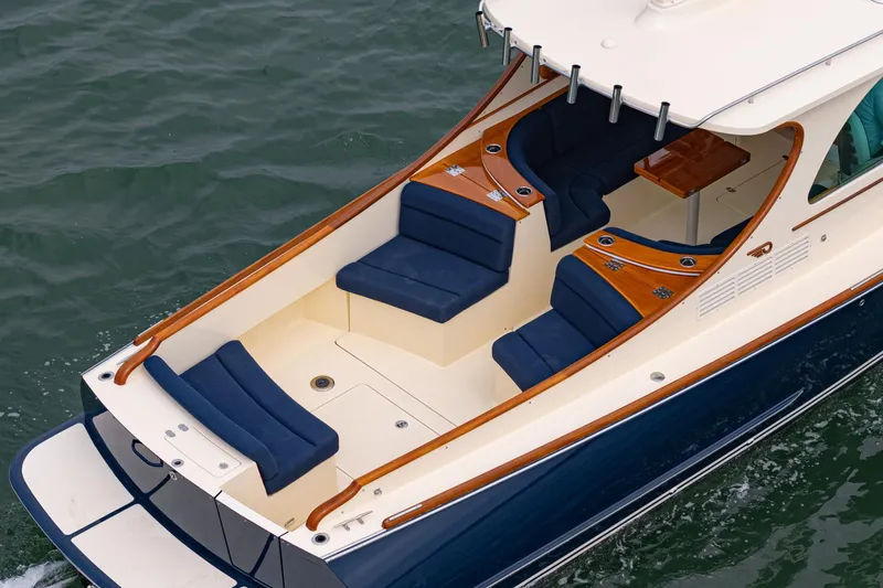 Slide: The Image of 2014 Hinckley Talaria 34 boat with elegant seating and wooden accents on the water. - 8