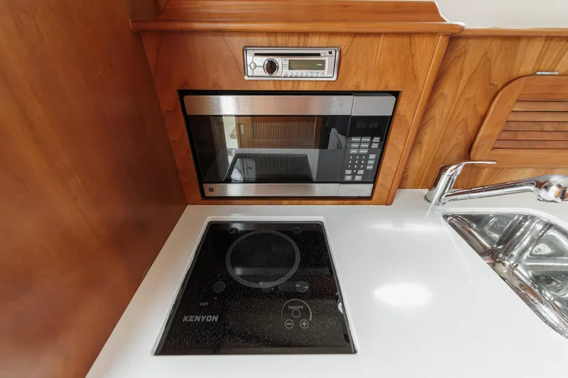 Slide: The Image of Hinckley Talaria 34 yacht kitchen with microwave, stove, and sink, 2014 model. - 28