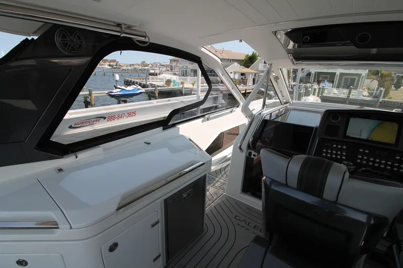 Slide: The Image of Interior view of 2022 Galeon 325 GTO yacht, featuring modern cockpit and waterfront backdrop. - 15