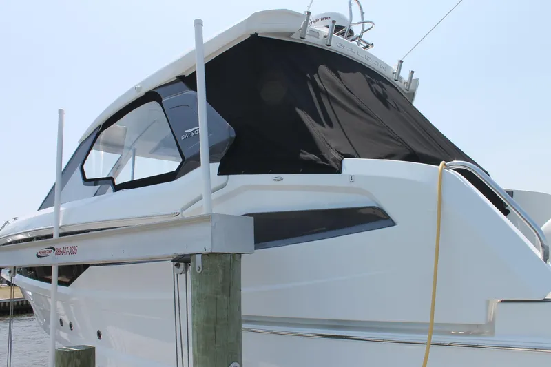 Slide: The Image of 2022 Galeon 325 GTO yacht docked, featuring sleek design and black canopy. - 2