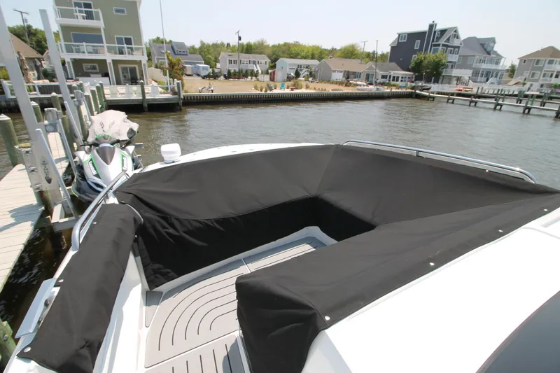 Slide: The Image of 2022 Galeon 325 GTO boat with black seating cover docked near waterfront homes. - 4