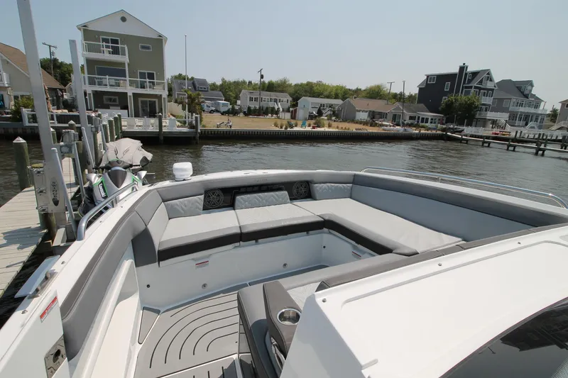 Slide: The Image of 2022 Galeon 325 GTO boat with spacious seating, docked near waterfront homes. - 6