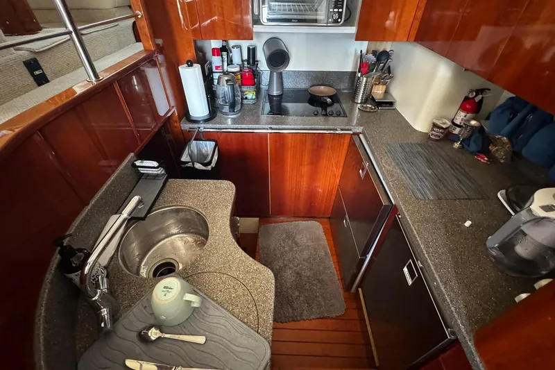 Slide: The Image of Luxurious 2001 Fairline 55 yacht kitchen with modern appliances and elegant wood cabinetry. - 33