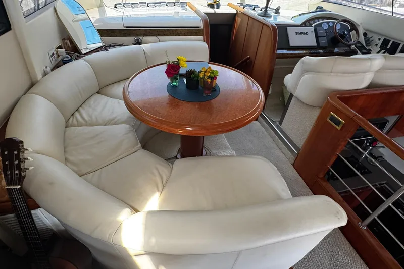 Slide: The Image of Luxurious interior of 2001 Fairline 55 yacht with plush seating and elegant wooden table. - 39