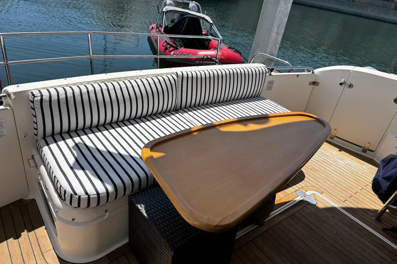 Slide: The Image of Outdoor seating area on 2001 Fairline 55 yacht with striped cushions and wooden table. - 44