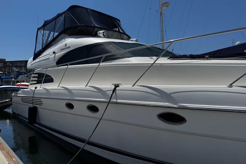 Slide: The Image of Luxury 2001 Fairline 55 yacht docked at marina under clear blue sky. - 5