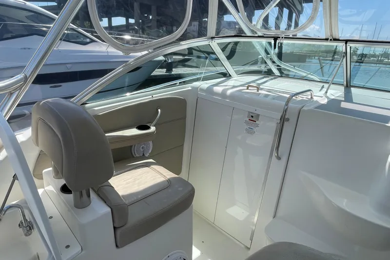 Slide: The Image of 2002 Wellcraft 290 Coastal boat cockpit with steering wheel, seating, and control panel. - 10