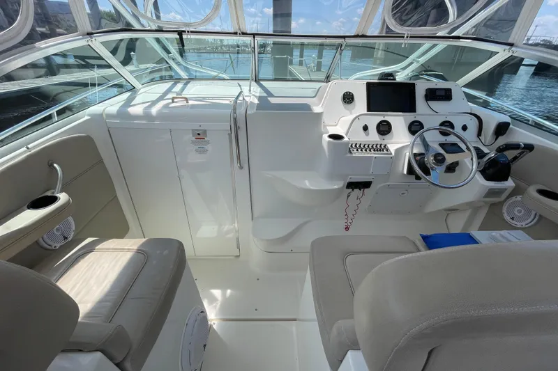 Slide: The Image of 2002 Wellcraft 290 Coastal boat interior with seating and helm, under sunny skies. - 11