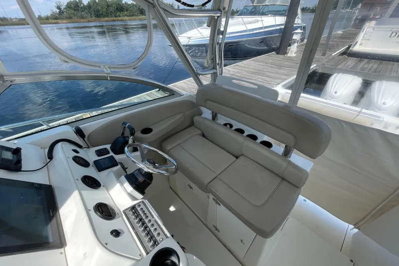 Slide: The Image of 2002 Wellcraft 290 Coastal boat dashboard with steering wheel and navigation controls. - 13