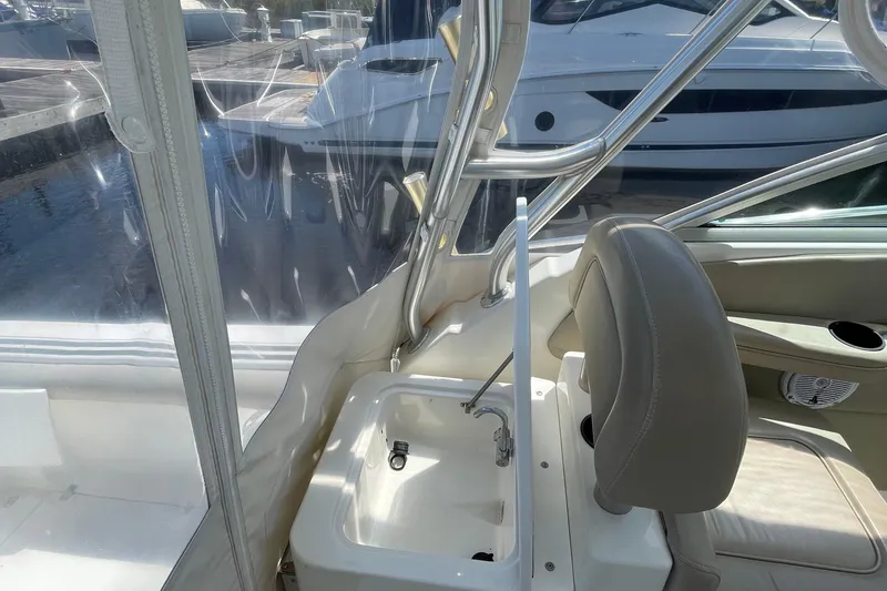 Slide: The Image of 2002 Wellcraft 290 Coastal boat interior with helm seat and docked boats in background. - 16