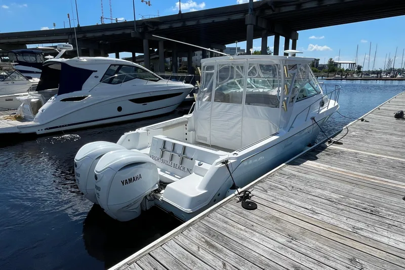 Slide: The Image of 2002 Wellcraft 290 Coastal boat docked with twin Yamaha engines, sunny marina setting. - 4