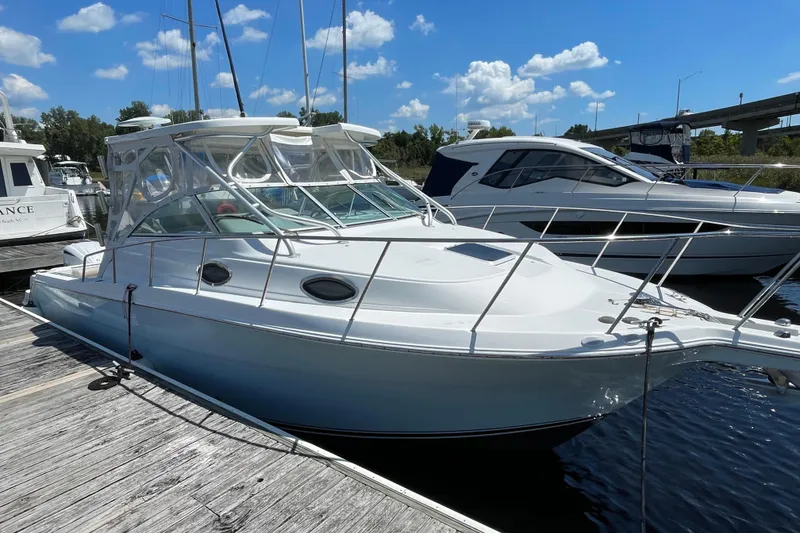 Slide: The Image of 2002 Wellcraft 290 Coastal boat docked at marina under blue sky. - 5