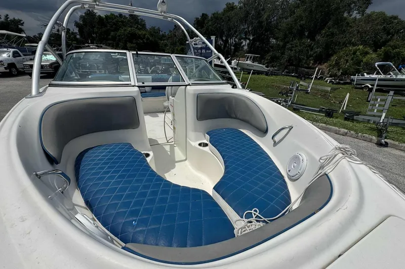 Slide: The Image of 2011 Sea Ray 205 Sport boat with blue seating, parked outdoors. - 4