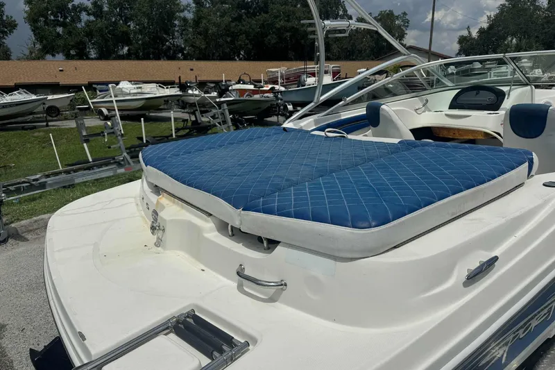 Slide: The Image of 2011 Sea Ray 205 Sport boat with blue cushioned seating, parked outdoors. - 7