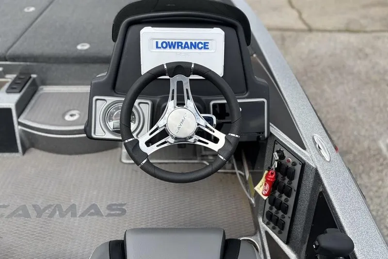Slide: The Image of 2023 Caymas CX 19 boat dashboard with Lowrance display and steering wheel. - 13