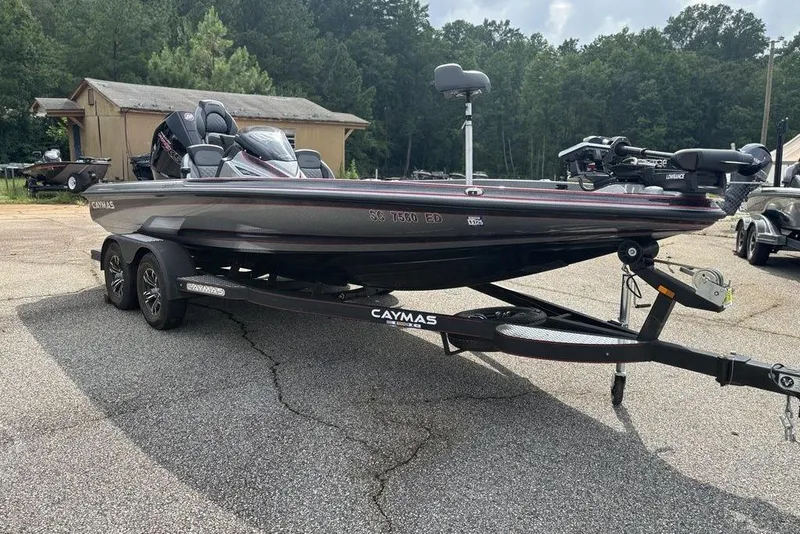 Slide: The Image of 2023 Caymas CX 19 boat on trailer, parked outdoors with trees in background. - 5