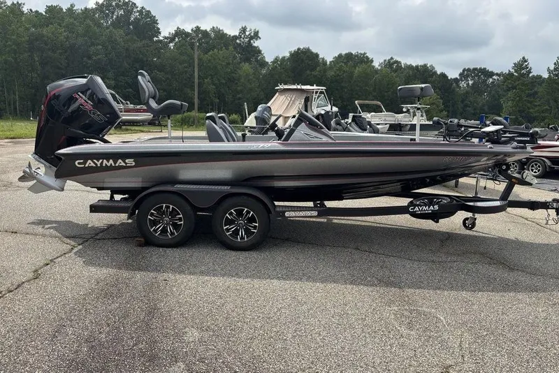 Slide: The Image of 2023 Caymas CX 19 boat on trailer, parked outdoors with trees in background. - 7