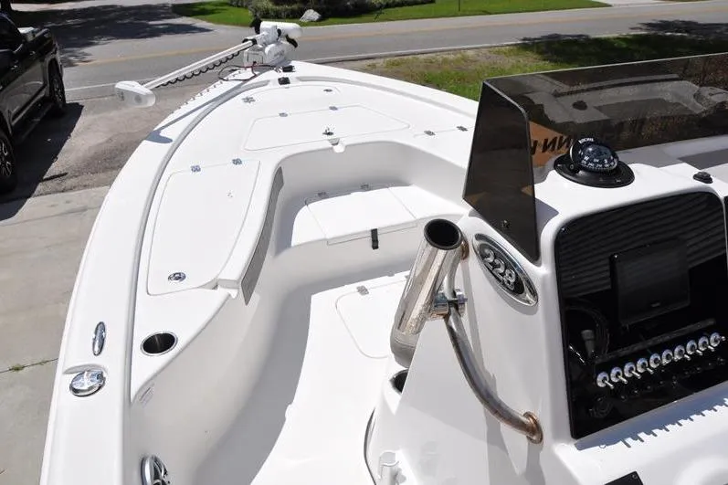 Slide: The Image of 2021 Sea Pro 228 Bay boat interior with console and seating, parked on driveway. - 23