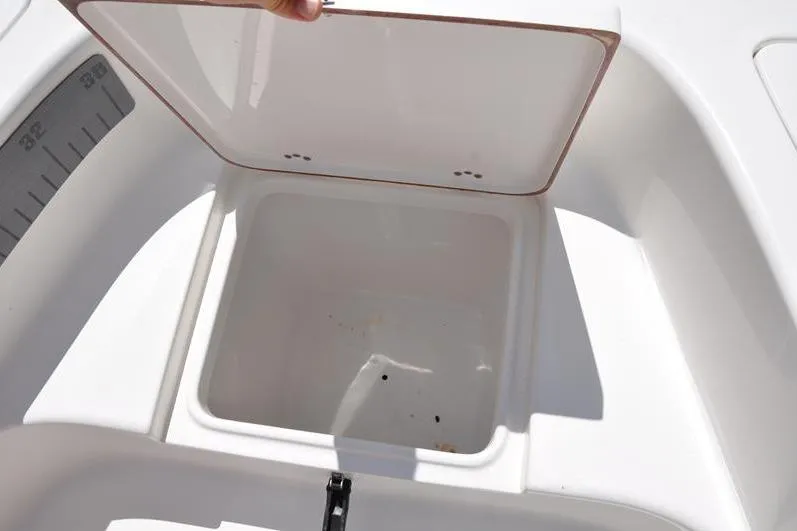 Slide: The Image of 2021 Sea Pro 228 Bay boat storage compartment with open lid, showcasing interior space. - 30