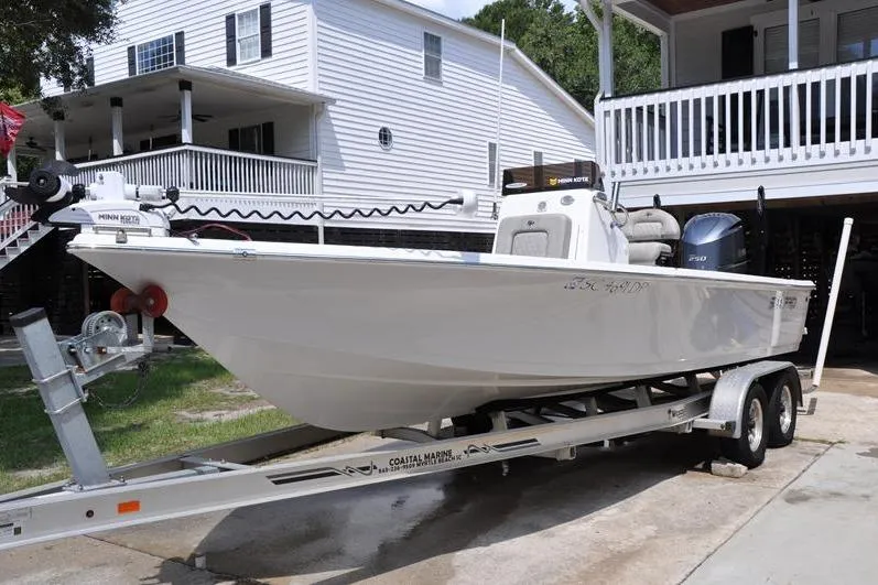 Slide: The Image of 2021 Sea Pro 228 Bay boat on trailer, parked in front of a white house. - 4