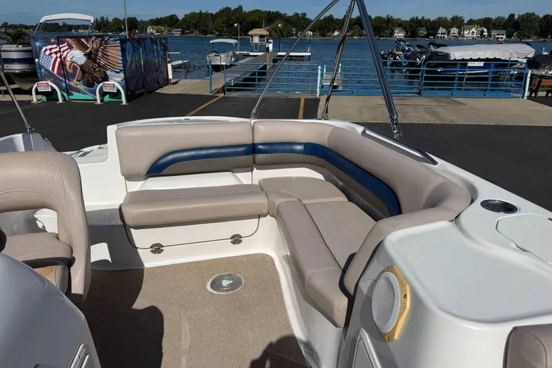 Slide: The Image of 2013 Hurricane 188 boat interior with beige and blue seating, docked by a lake. - 13