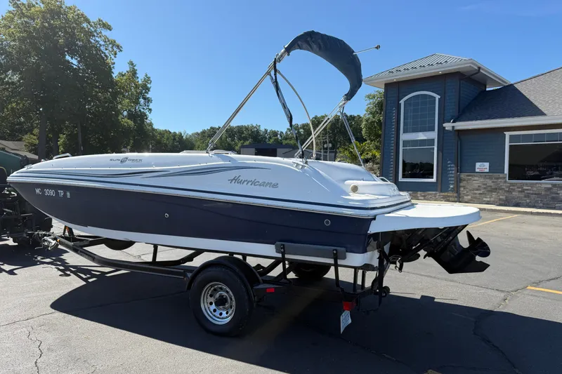 Slide: The Image of 2013 Hurricane 188 boat on trailer, parked outside a building on a sunny day. - 17