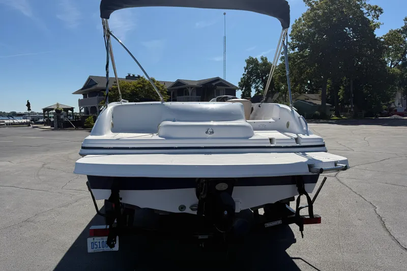Slide: The Image of 2013 Hurricane 188 boat with canopy, parked on a sunny day near waterfront homes. - 6