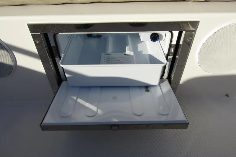 Slide: The Image of Open storage compartment on 2025 Nimbus Tender 9 boat, featuring a white interior tray. - 33