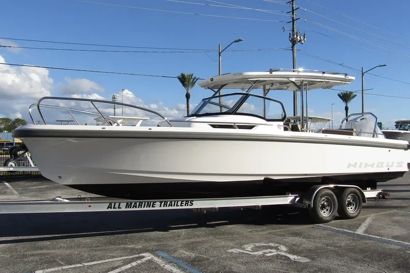 Slide: The Image of 2025 Nimbus Tender 9 boat on trailer, parked outdoors under clear sky. - 7