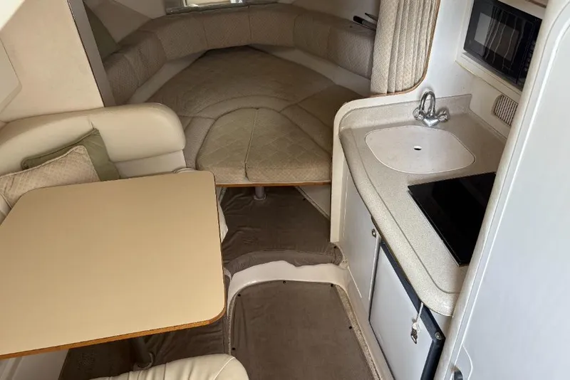 Slide: The Image of Interior of a 1999 Sea Ray 270 Sundancer boat with kitchenette and seating area. - 3