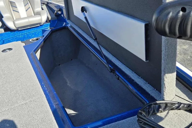 Slide: The Image of 2024 Nitro Z18 boat storage compartment with blue trim and gray interior. - 13