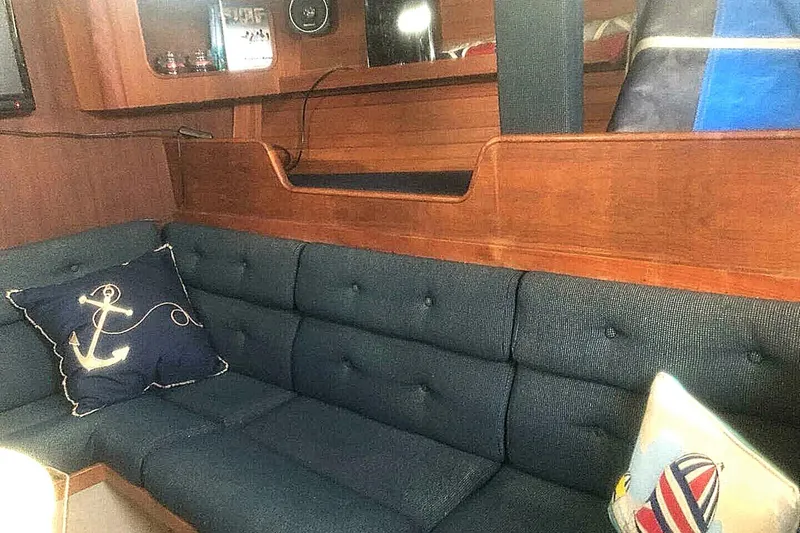 Slide: The Image of Interior of 1988 C&C 44 yacht with navy cushions and nautical-themed pillows. - 11