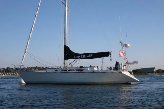 Slide: The Image of 1988 C&C 44 sailboat on calm water, featuring sleek design and American flag. - 16