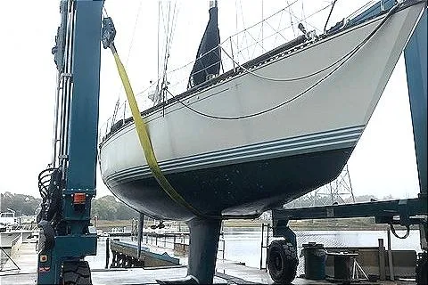 Slide: The Image of 1988 C&C 44 sailboat being lifted by a marina crane. - 17