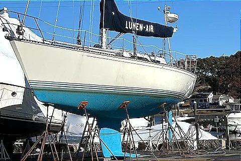 Slide: The Image of 1988 C&C 44 sailboat on stands, with blue hull and "Lumen-Air" sail cover. - 18