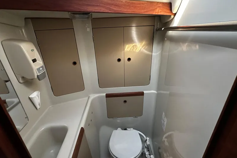Slide: The Image of 1988 C&C 44 yacht bathroom with sink, toilet, and storage cabinets. - 20