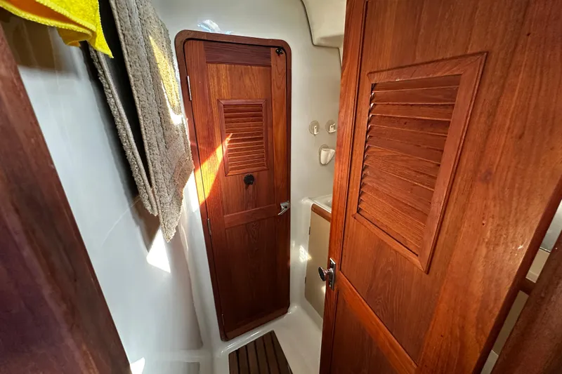Slide: The Image of 1988 C&C 44 yacht interior with wooden doors and cozy bathroom space. - 24