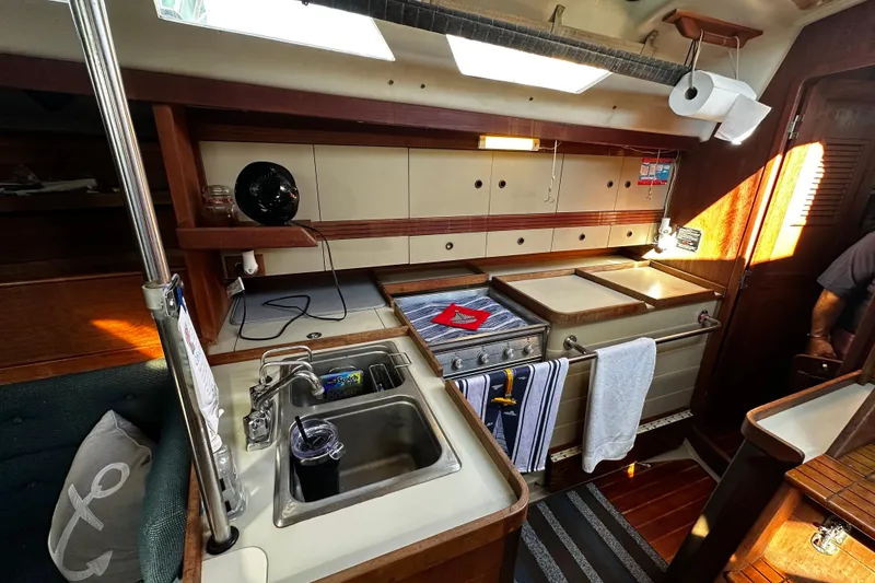 Slide: The Image of 1988 C&C 44 yacht interior kitchen with sink, stove, and storage cabinets. - 26
