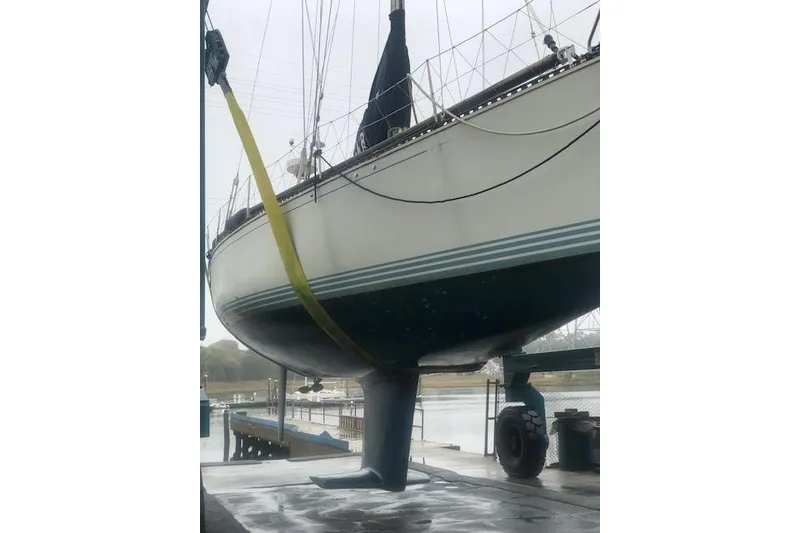 Slide: The Image of 1988 C&C 44 sailboat in dry dock, supported by straps, with visible keel. - 27