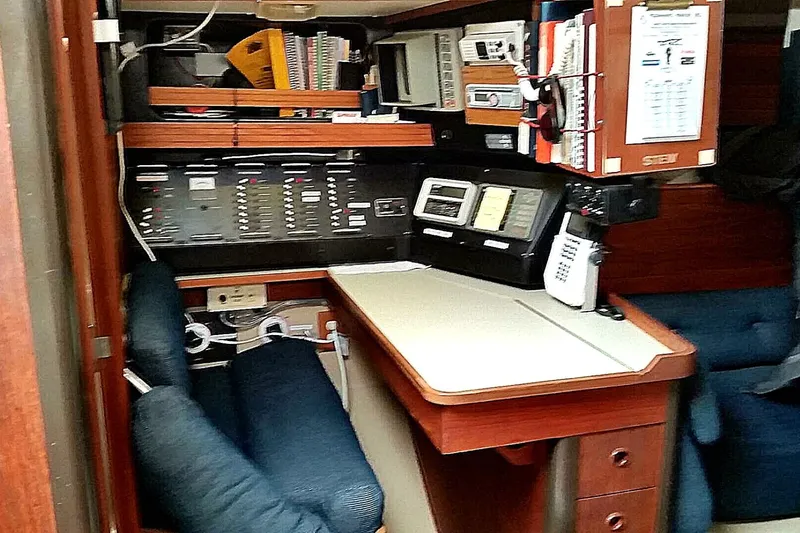 Slide: The Image of Navigation station inside a 1988 C&C 44 sailboat, featuring control panels and communication equipment. - 7