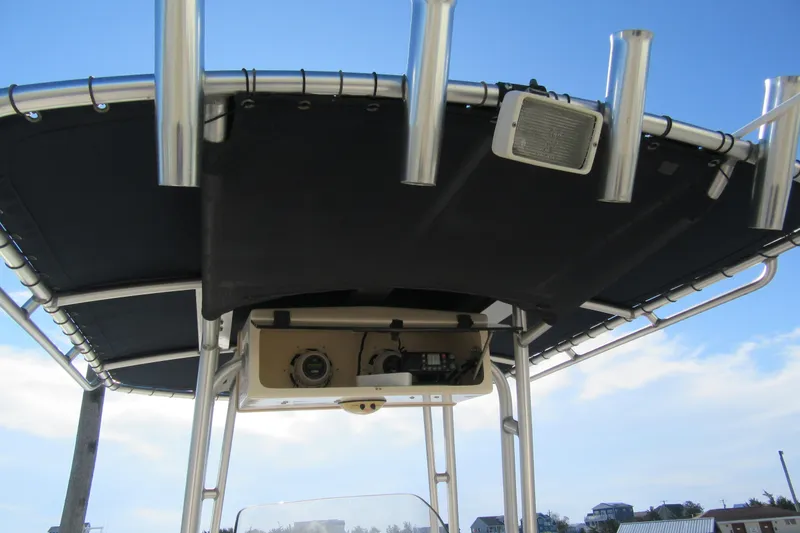Slide: The Image of 2004 Grady-White Fisherman 222 T-top with rod holders and speaker, under blue sky. - 11