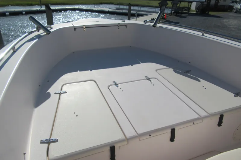 Slide: The Image of 2004 Grady-White Fisherman 222 boat deck with storage compartments, docked by the water. - 8