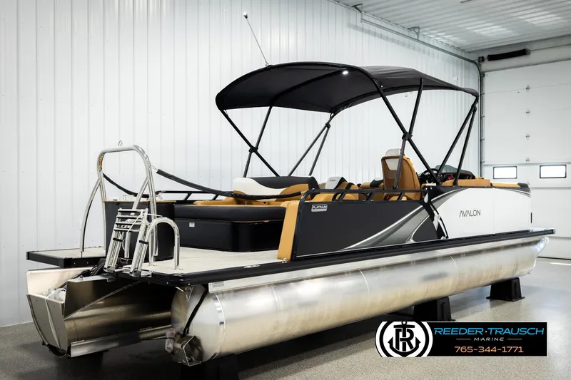 Slide: The Image of 2026 Avalon LSZ VRB pontoon boat in showroom with sleek design and canopy. - 6