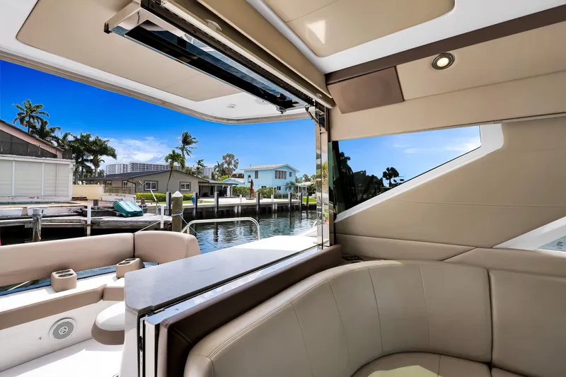 Slide: The Image of Interior view of 2017 Regal 53 Sport Coupe yacht, showcasing luxurious seating and waterfront scenery. - 37