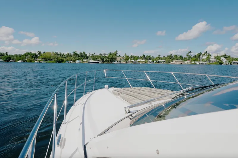 Slide: The Image of 2017 Regal 53 Sport Coupe yacht cruising on a sunny day, with waterfront homes in the background. - 11