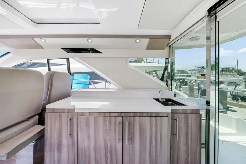 Slide: The Image of Luxurious interior of 2017 Regal 53 Sport Coupe yacht with modern kitchenette and seating. - 18