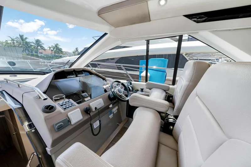 Slide: The Image of Interior of 2017 Regal 53 Sport Coupe yacht, featuring modern helm and luxurious seating. - 21